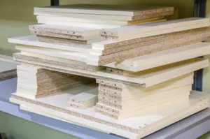 Stacked white MDF and particleboard panels used for mass-produced furniture.
