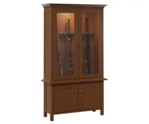 Narrow wood gun cabinet with two glass doors, interior lighting, and enclosed base storage.