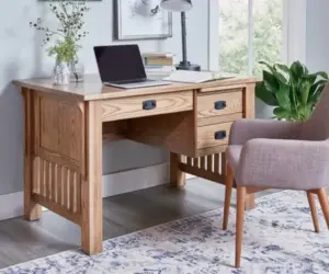Solid wood writing desk with drawers in a bright home office.