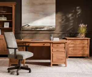 Solid wood office desk with matching file cabinet and bookcase in a dark, modern workspace.